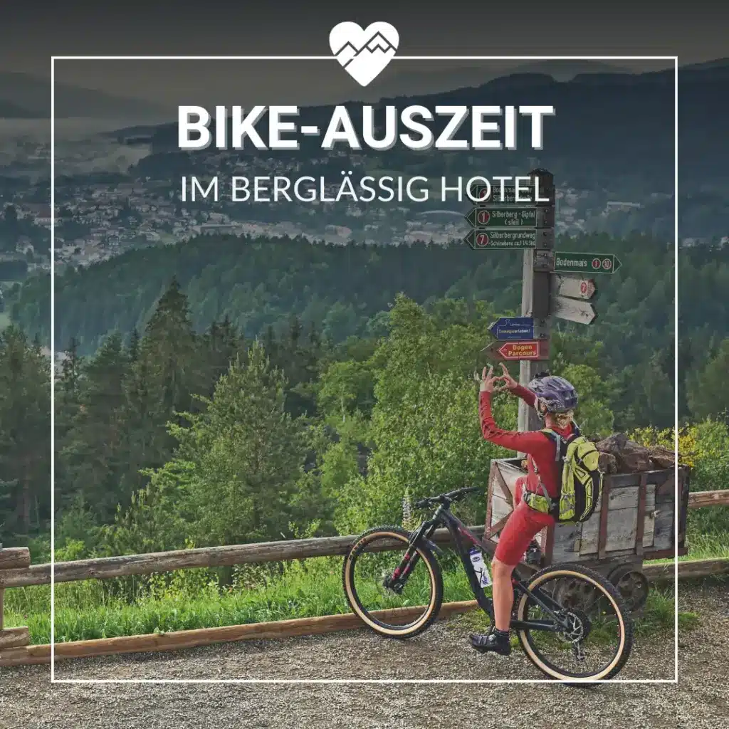 Radfahrer, der ein Foto an einem Aussichtspunkt in den Bergen mit Wald und Stadt im Hintergrund macht; deutscher Text überlagert.