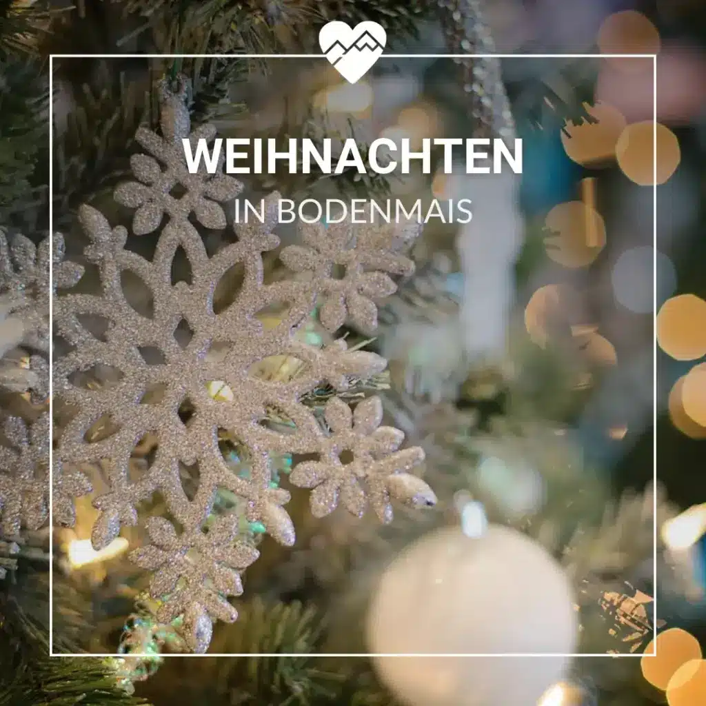 Nahaufnahme eines glitzernden Schneeflockenornaments an einem Weihnachtsbaum mit Text: Weihnachten in Bodenmais.