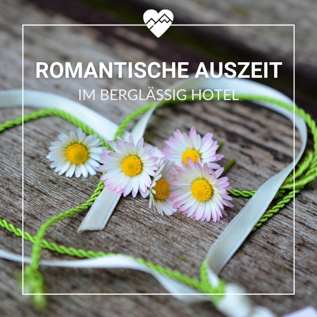 Wei&szlig;e und gelbe G&auml;nsebl&uuml;mchen mit gr&uuml;nen und wei&szlig;en B&auml;ndern auf Holzoberfl&auml;che, Text: "Romantische Auszeit im Bergl&auml;ssig Hotel".