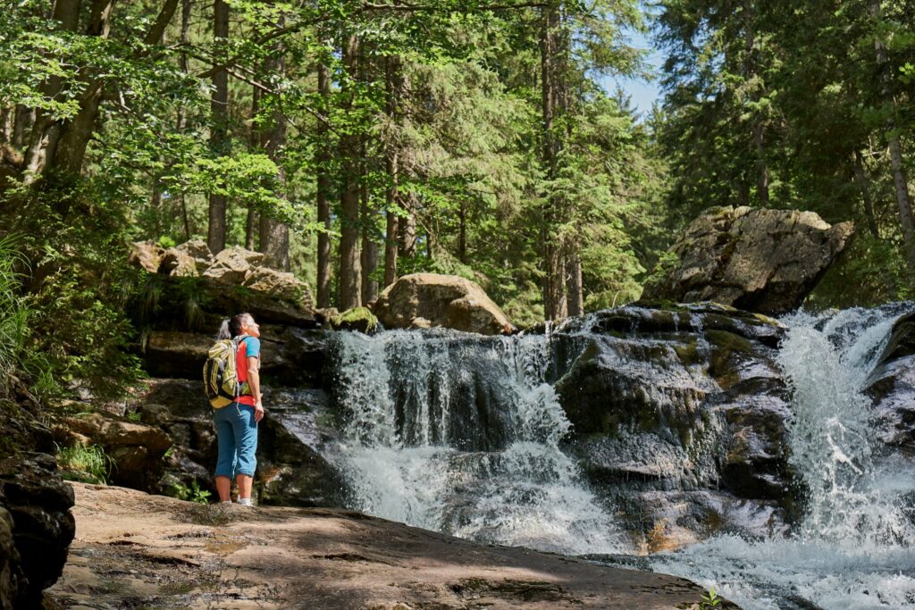 Wanderer am Wasserfall im Riesloch