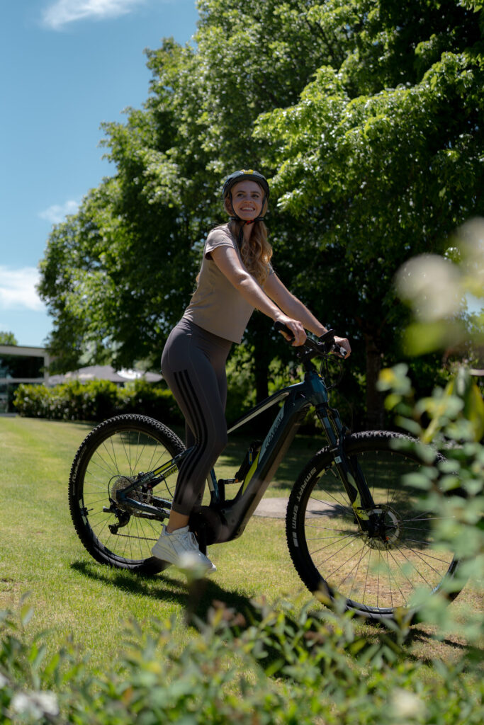 Frau auf dem E-Bike auf einer Wiese bei Bodenmais
