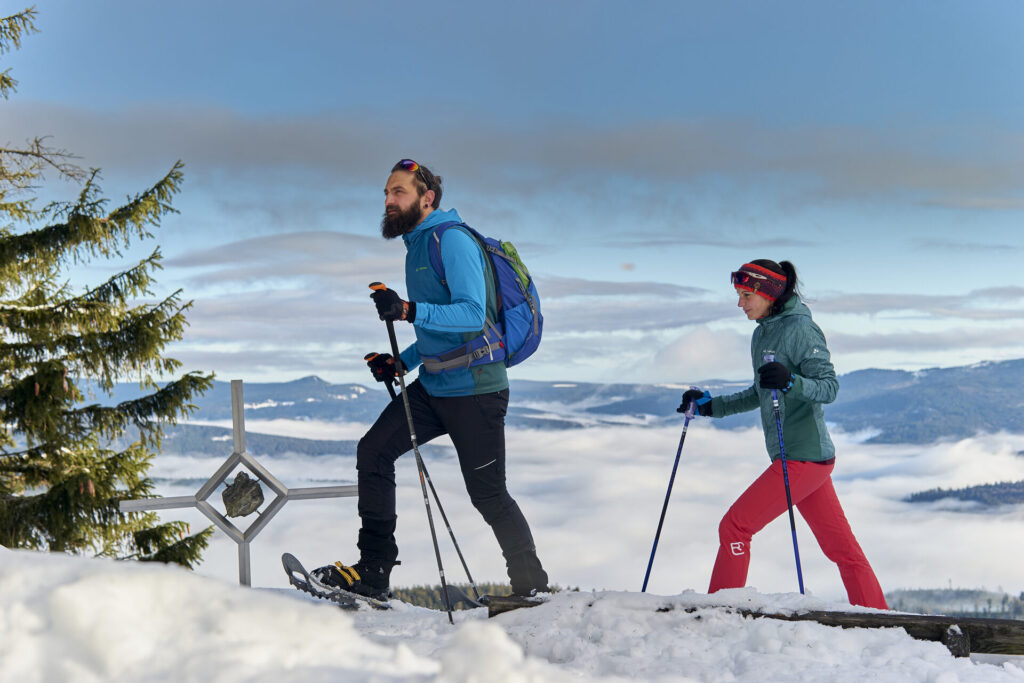 Zwei Schneeschuhwanderer auf einer Höhe im Bayerischen Wald
