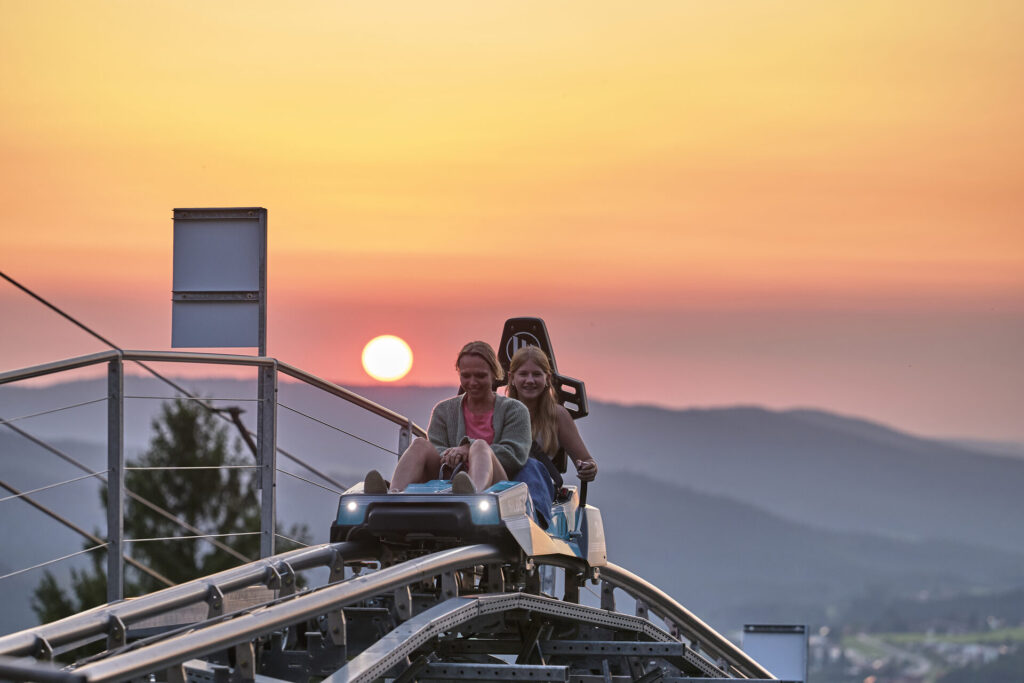 Familie im Silberberg-Coaster bei Sonnenuntergang in Bodenmais