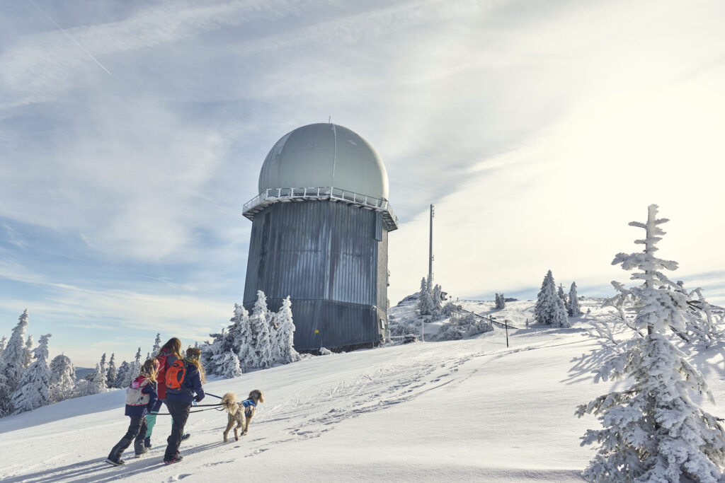 Winterwanderer mit Hund am verschneiten Großen Arber bei Bodenmais