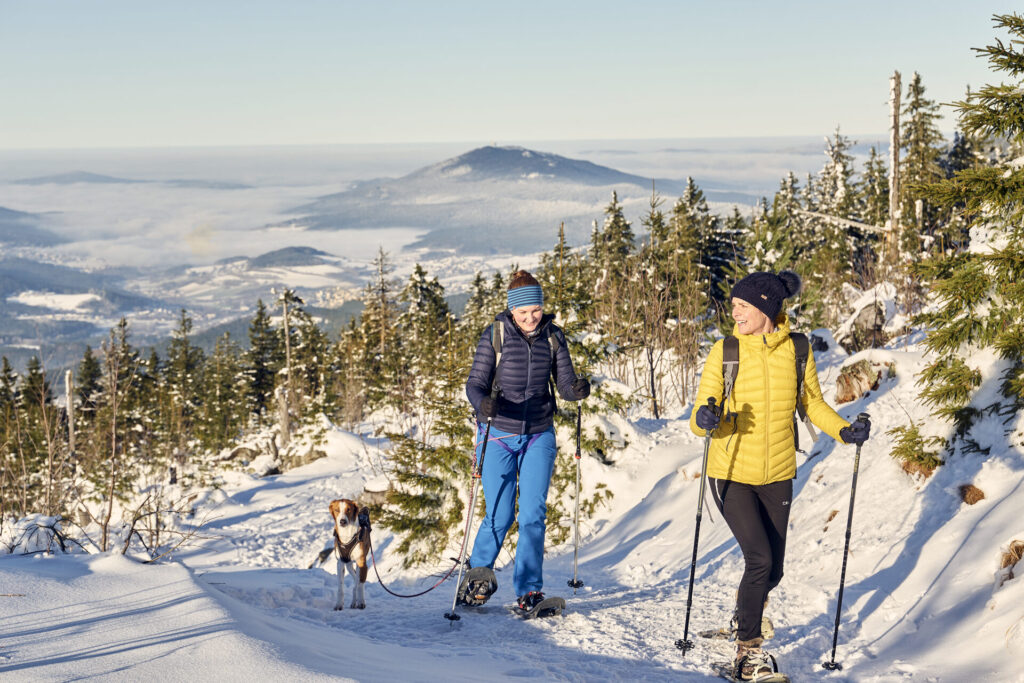 Paar beim Winterwandern mit Stöcken im Bayerischen Wald
